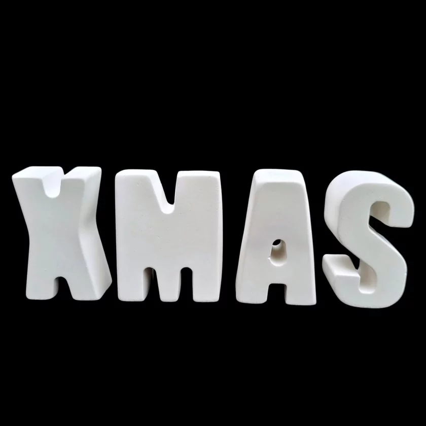 Weißer Buchstaben-Schriftzug "XMAS" aus Raysin vor schwarzem Hintergrund